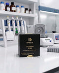 A black box of Genetic Labs GHK-CU 50 MG powder for laboratory research use only, placed on a white lab bench with pipettes, bottles, and other lab equipment in the blurred background.